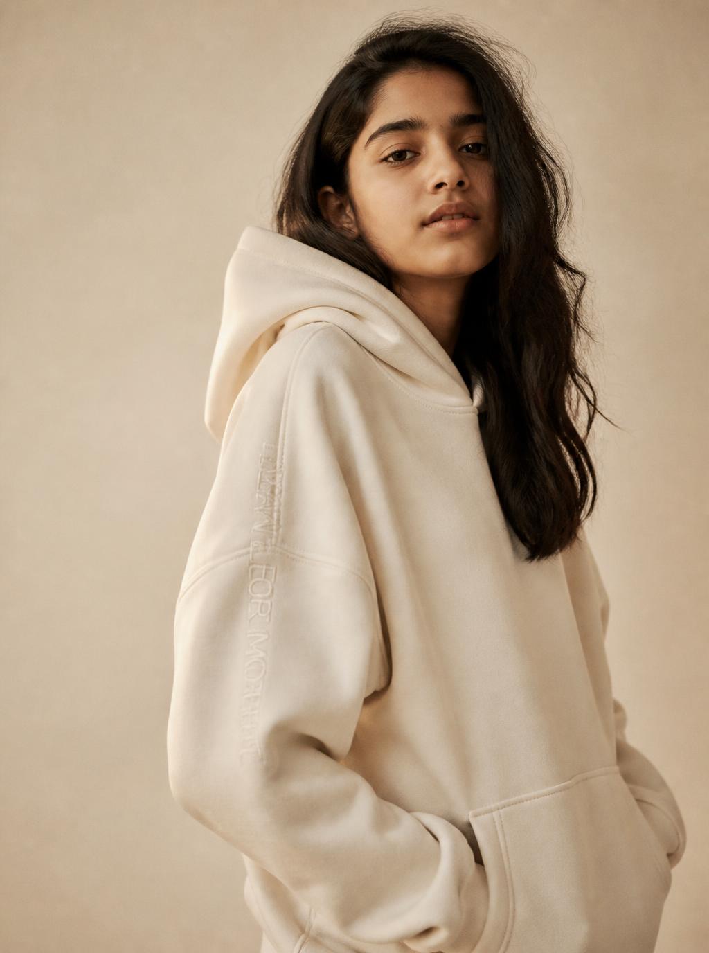 Teenage girl wearing an oversized bone MARVAB hoodie