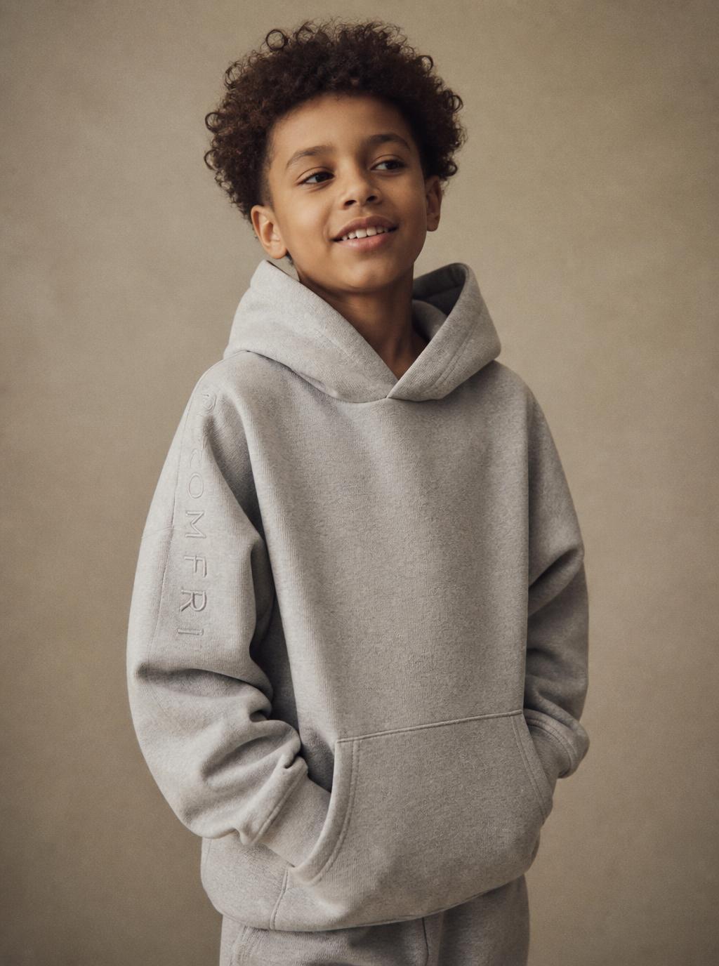 Young boy wearing an oversized heather grey MARVAB hoodie